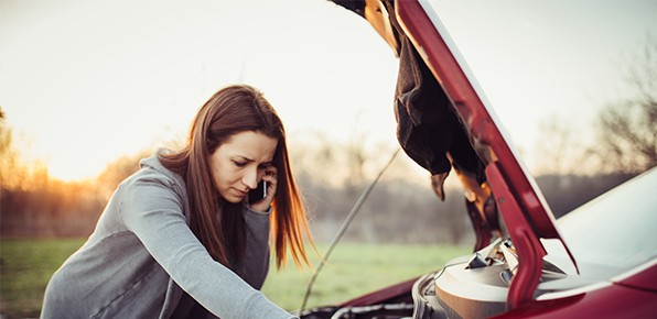 Woman-Standing-Over-Broken-Down-Car