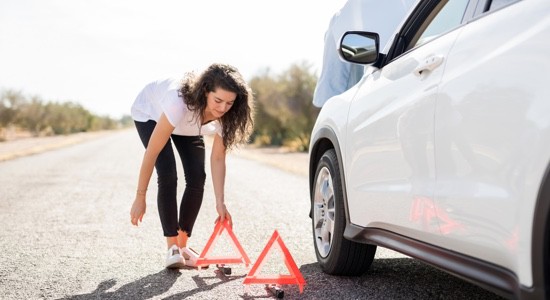 Woman-Placing-Triangles-Near-Car-Breakdown