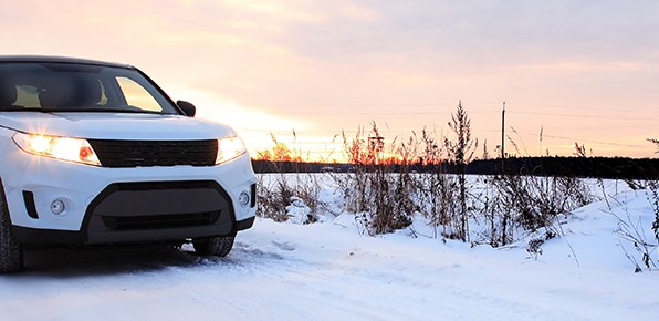 Vehicle-on-Snowy-Road-at-Sunrise