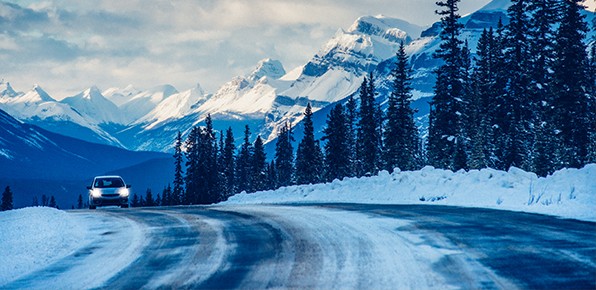 Car-On-Snowy-Road-With-Headlights-On